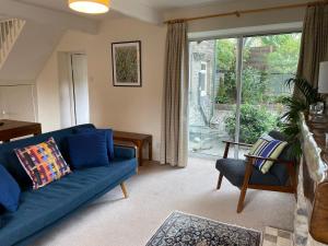 a living room with a blue couch and a window at Bluebell Cottage in the Yorkshire Dales in Stainforth +8 photos