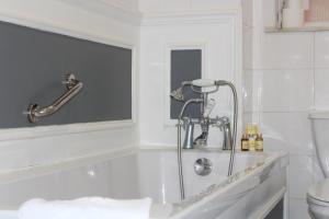a bathroom with a bath tub with a faucet at The Town House in Arundel