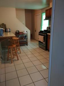 a kitchen with a tiled floor with a stove and stools at 320 Happy Home in Chicago