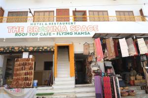een gebouw met een bord dat het biryaniarmaswick café op het dak leest bij The Brahma Space in Pushkar