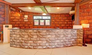 a bar in a room with a stone wall at Treebo Trend Vhyomaan Resort in Mahabaleshwar