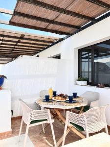 una mesa y sillas en un patio con una comida en Apartamento La Gaviota, en Playa Honda