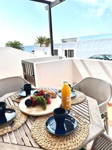una mesa con un plato de comida y una botella de zumo de naranja en Apartamento La Gaviota, en Playa Honda
