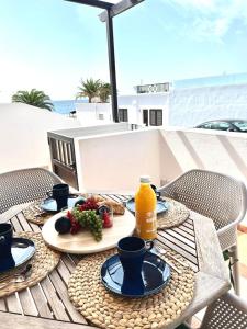 a table with a plate of food and a bottle of orange juice at Apartamento La Gaviota in Playa Honda