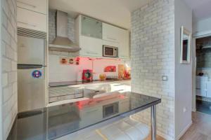Apartamento loft en plaza España - gran vía في مدريد: مطبخ مع كونتر زجاجي في الوسط