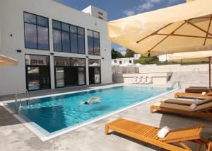 a person swimming in a swimming pool next to a building at Nordic Resort in Novi Sad