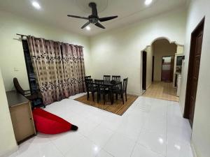 un soggiorno con tavolo e ventilatore a soffitto di Cendana Residence Homestay Pengadang Baru Kuala Terengganu a Kuala Terengganu