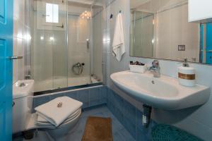 a bathroom with a sink and a toilet and a shower at Milos Sunset Home in Tripiti