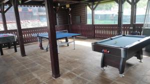 two ping pong tables in a room with a pool table at Pensiunea POPASUL CODRENILOR in Homorodu de Sus