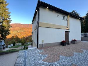 un gran edificio blanco con un patio de ladrillo en Villa Igman - فيلا سراييفو, en Hadžići