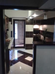 Il comprend une cuisine dotée de carrelage noir et blanc. dans l'établissement Apartament Slanic Moldova, à Slănic-Moldova