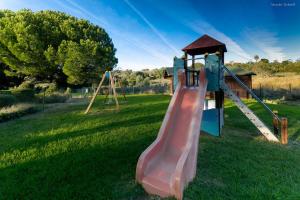 un parco giochi con scivolo rosa in un campo di MarinaPark Hill Beach Apartment a Lagos