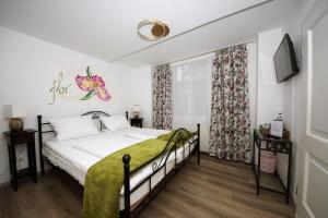 - une chambre avec un lit et une couverture verte dans l'établissement Liebezeit - ehemals Hotel Dillenburg, à Dillenburg