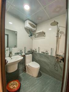 a bathroom with a white toilet and a sink at Sơn Tùng Hostel in Cat Ba