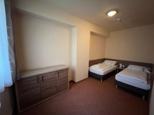 Habitación pequeña con 2 camas y armario en Centrooms Eger en Eger