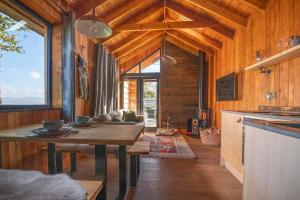 a kitchen with a table in a room with wooden walls at Sied Potio in Newborough