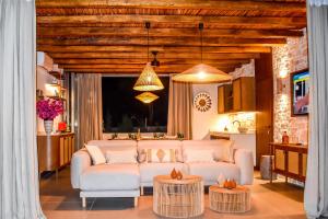 a living room with a white couch and two tables at Mandraki Village Boutique Hotel in Koukounaries