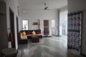 a living room with a couch with red and yellow pillows at Sukh Sagar Homestay in Chittaurgarh