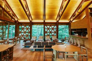 軽井沢町にあるSHISHI-IWA-HOUSE Karuizawaの木製の天井、テーブルと椅子のあるレストラン