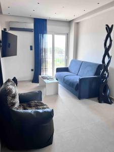 a living room with a blue couch and a tv at Lagonisi 2 bedroom luxury Apartment by the sea! in Lagonissi