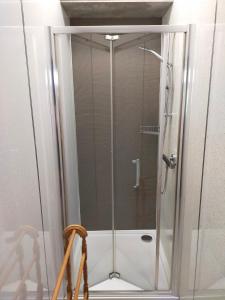a shower with a glass door in a bathroom at Lucker mill shepherds huts in Lucker