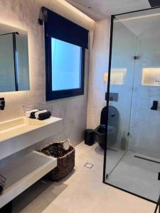 uma casa de banho com uma cabina de duche em vidro e um WC. em Lagonisi 2 bedroom luxury Apartment by the sea! em Lagonissi
