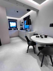 cocina blanca con mesa blanca y sillas en Lagonisi 2 bedroom luxury Apartment by the sea!, en Lagonisi