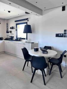 a kitchen with a table and chairs in a room at Lagonisi 2 bedroom luxury Apartment by the sea! in Lagonissi
