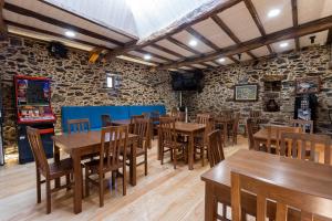 un restaurante con mesas de madera y sillas en una habitación en Hotel Donas e Cabaleiros, en Pousada