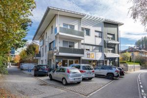 a building with cars parked in a parking lot at City Café - CENTRAL Apartment in Brunico