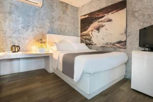 a bedroom with a bed and a sink and a tv at Ilio Maris in Mikonos