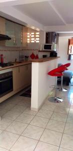 a kitchen with a red stool in a room at Appartement d'une chambre avec terrasse amenagee et wifi a Le Robert in Le Robert