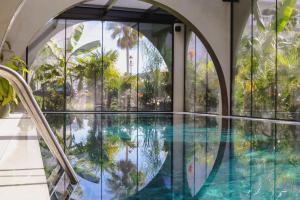 una piscina in un edificio con finestre in vetro di Flower Hotels & Resorts a Golem