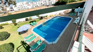 an overhead view of a swimming pool with chairs and umbrellas at Albufeira Calipto by Sunny Deluxe in Albufeira