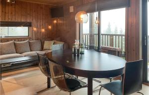 comedor con mesa, sillas y sofá en Amazing Apartment In Sjusjen With House A Panoramic View en Sjusjøen