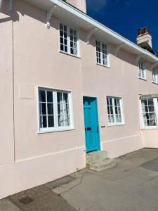 Casa blanca con puerta y ventanas azules en Benwick Cottage - Beachfront Thatched Cottage set on the marine parade with absolutely spectacular Sea views! Sleeps 4, en Lyme Regis