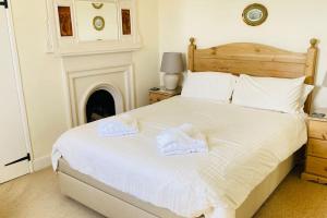 a bedroom with a bed with two towels on it at Benwick Cottage - Beachfront Thatched Cottage set on the marine parade with absolutely spectacular Sea views! Sleeps 4 in Lyme Regis