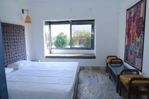 a bedroom with two beds and a window at The Brahma Space in Pushkar +25 photos