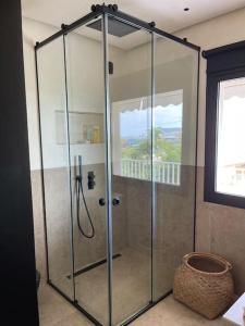 a shower stall with a glass door in a bathroom at Lagonisi Luxury appartment 2 by the sea in Lagonissi