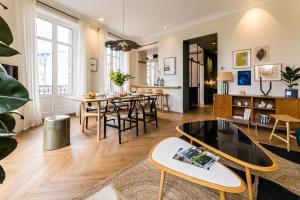 een woonkamer met een tafel en stoelen bij HYGGE KEYWEEK Apt 2 bedrooms with parking in Biarritz city center in Biarritz