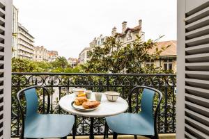 stół i krzesła na balkonie z jedzeniem w obiekcie HYGGE KEYWEEK Apt 2 bedrooms with parking in Biarritz city center w Biarritz +25 zdjęć
