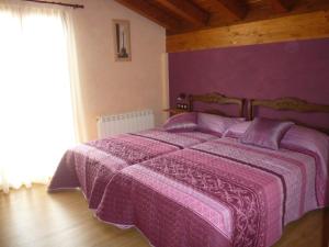 Dormitorio púrpura con cama con edredón púrpura en Casa Rural Ezkibel, 