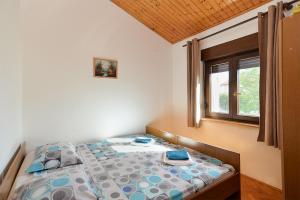a small bedroom with a bed with a window at Apartments Tanja 349 in Peroj