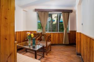 a living room with a table and a window at Muscatel Roma - 400 Mts from Mall Road in Darjeeling