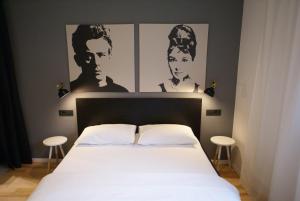 um quarto com uma cama com dois cartazes de homens em Fingerprint Tree Apartments - Original em Zagreb