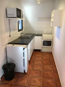 uma pequena cozinha com um lavatório e um micro-ondas em Agradable casa rural em Múrcia