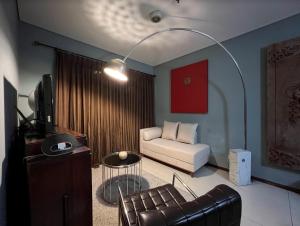 ein Wohnzimmer mit einem Sofa und einem Stuhl in der Unterkunft 2 Bedrooms - Thamrin Executive Apartment at Jakarta Center in Jakarta