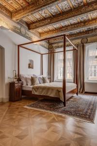 布拉格的住宿－Hotel Nerudova 211，一间卧室设有天蓬床和格子天花板