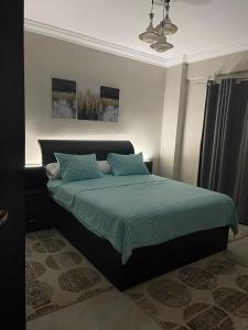 Two Bedroom at Sunny Lakes Resort في شرم الشيخ: غرفة نوم مع سرير مع لحاف أخضر