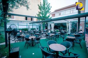 a group of tables and chairs on a patio at Hotel Bermon in Tirana